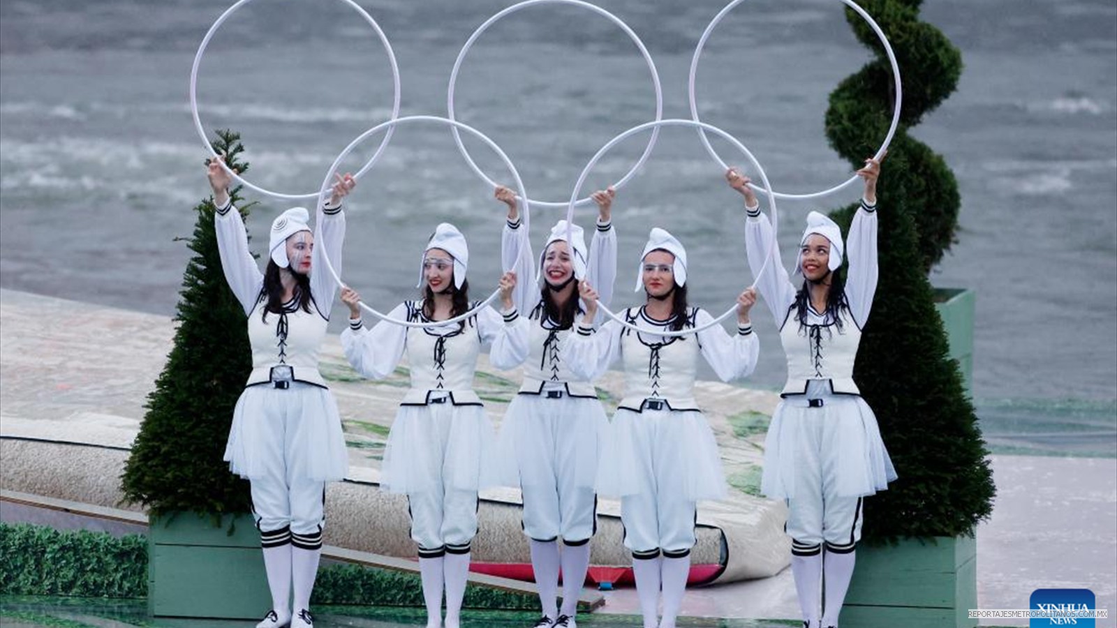 Los artistas sostienen aros con la forma de los anillos olímpicos en una plataforma flotante en el río Sena durante la ceremonia de apertura de los Juegos Olímpicos de París 2024